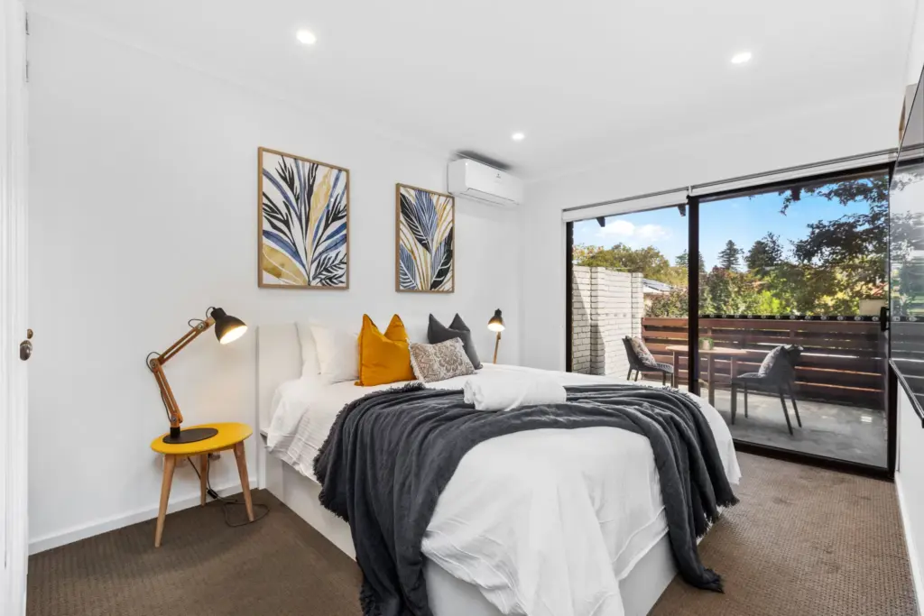Bedroom with sliding glass doors opening onto a private courtyard, professionally photographed